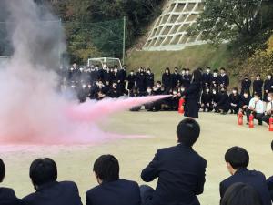 燃え盛る炎を消火器で消火する高校生