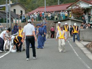 消火栓からホースを延ばす地域住民